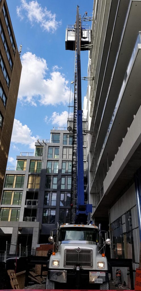 Mobile crane setup and vertical hoist mast on high-rise job site in Toronto and Burlington, Ontario
